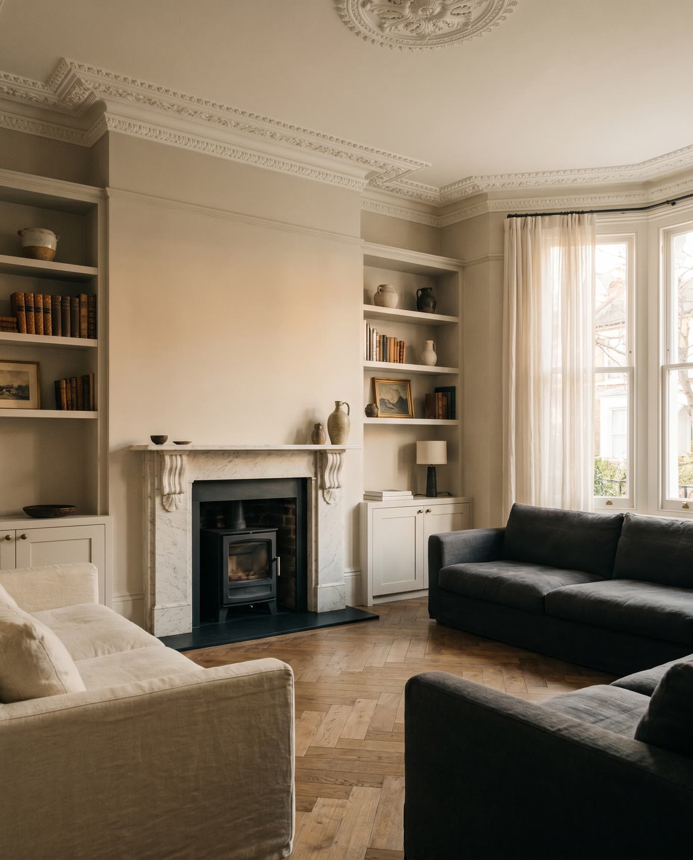 A Victorian living room with a marble fireplace and log burner