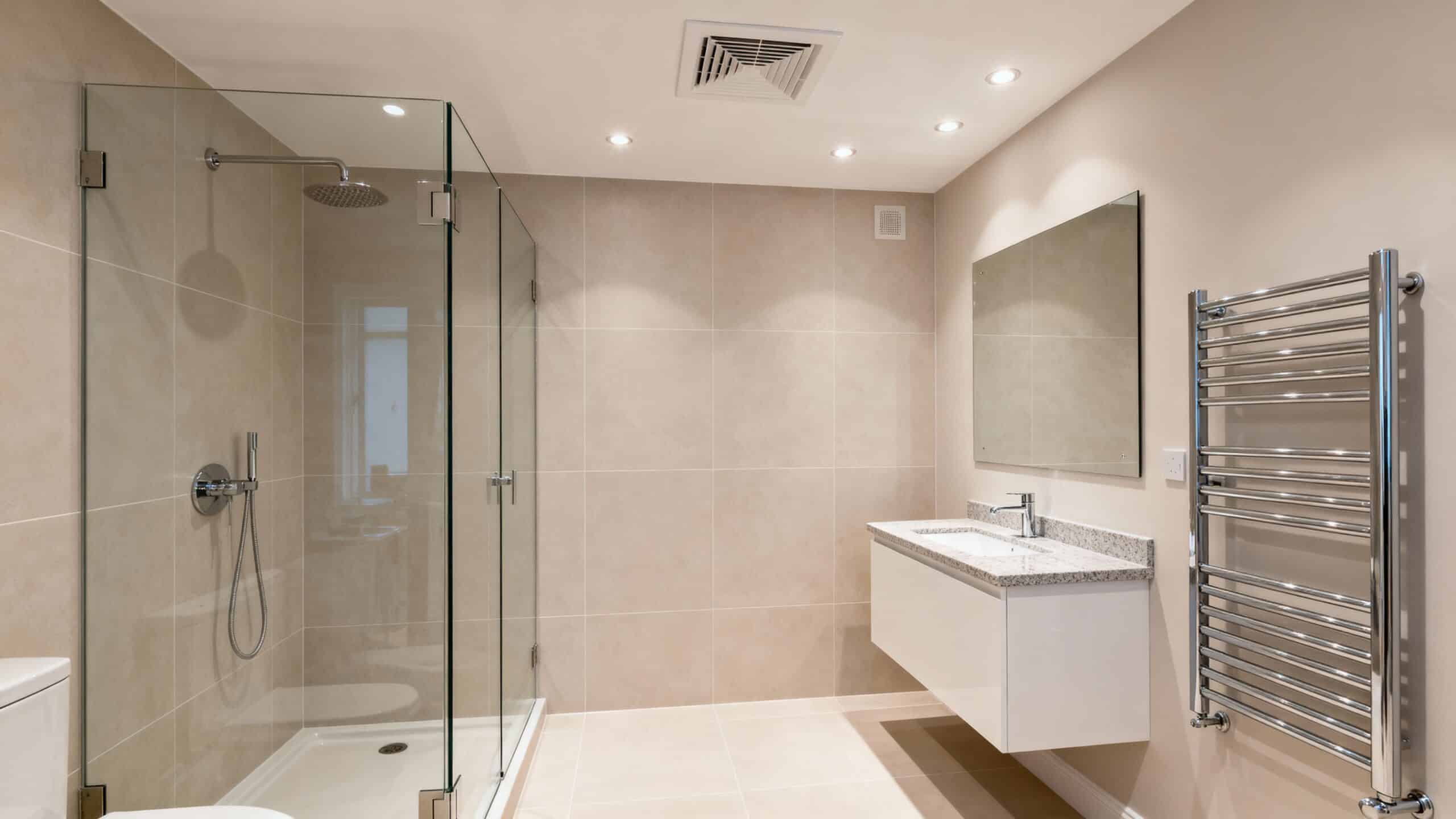 A bathroom featuring a shower, toilet, and sink, designed for functional and efficient use of space.